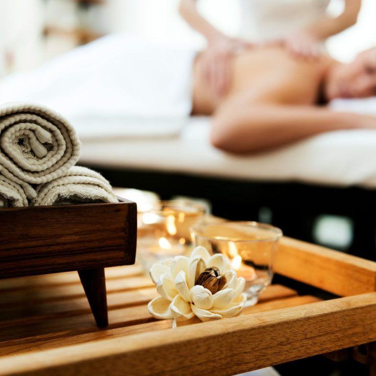 Wellness-Ambiente mit Handtüchern, Kerzen und Blüten bei Relax & More Unterhaching